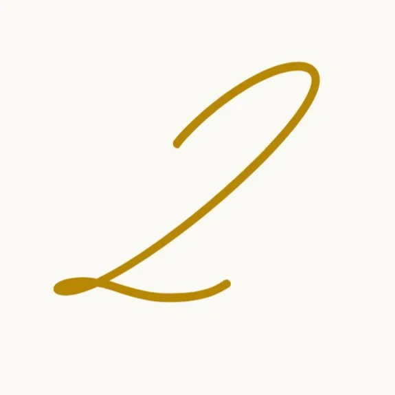 A gold cursive number 2 on a light background.