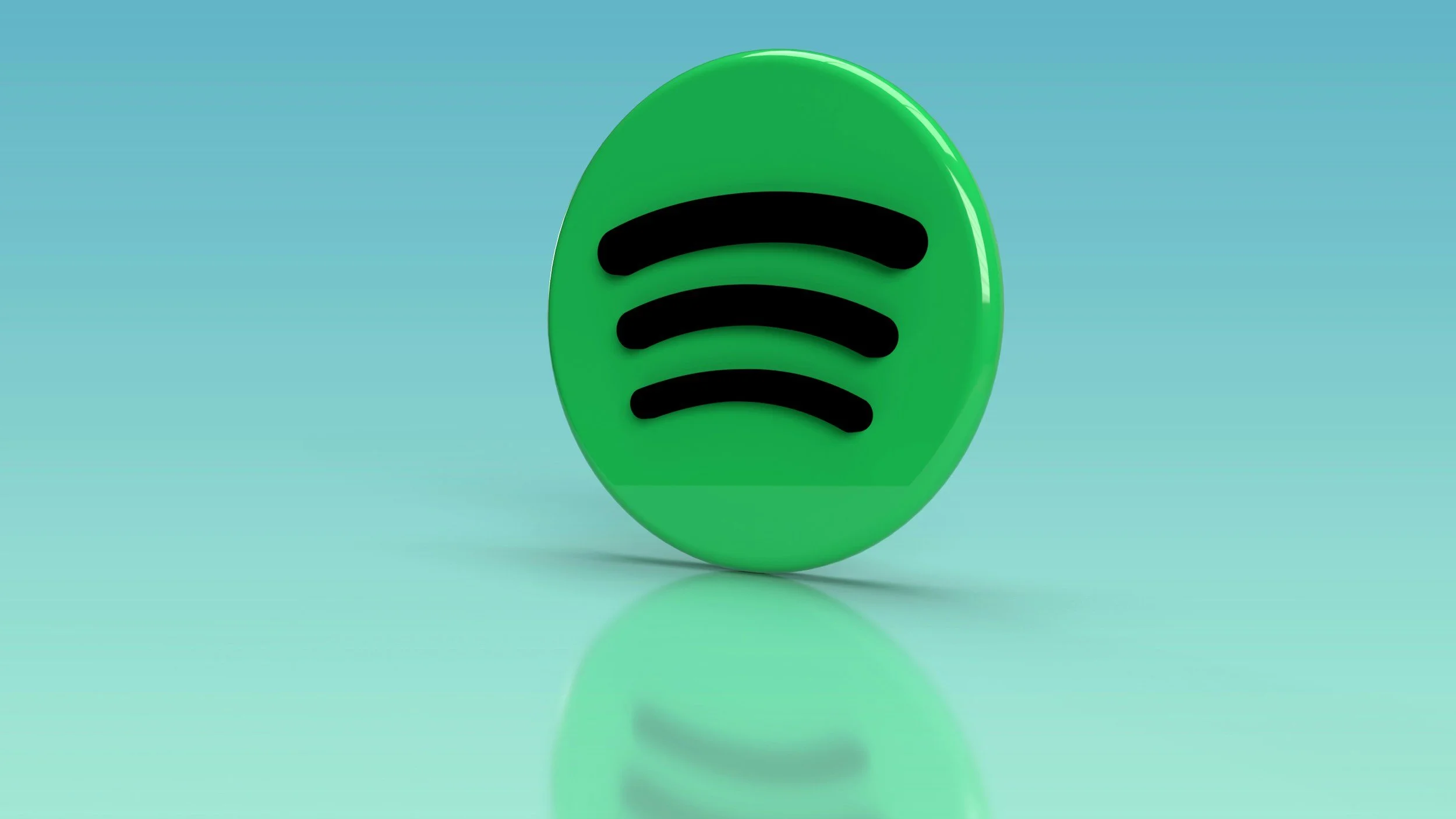 A 3D green oval icon with the black Spotify logo in the center, reflected on a glossy surface against a light blue background.