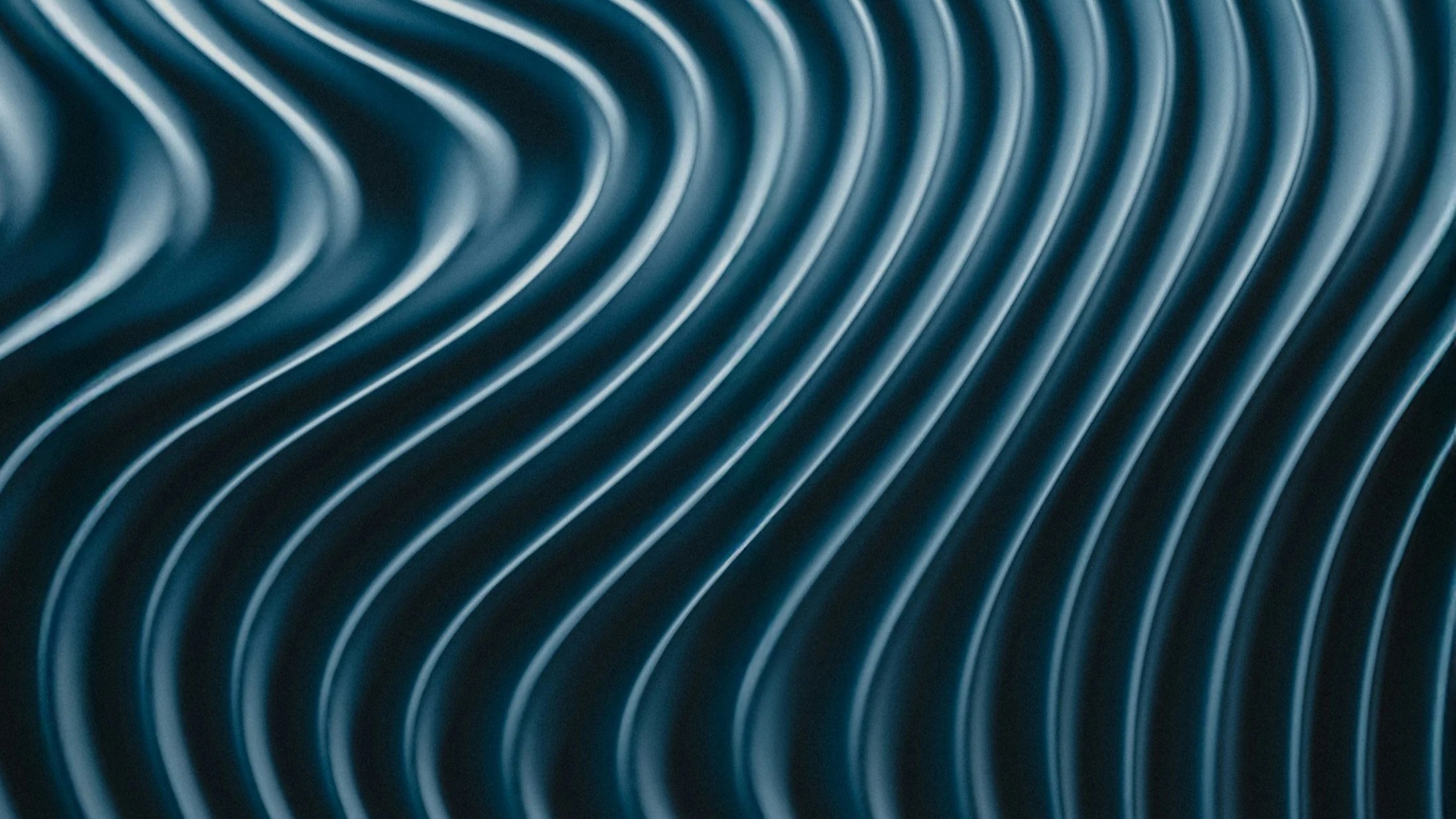 Close-up of a metallic, spiral-shaped vent or grill with shiny, reflective surfaces.