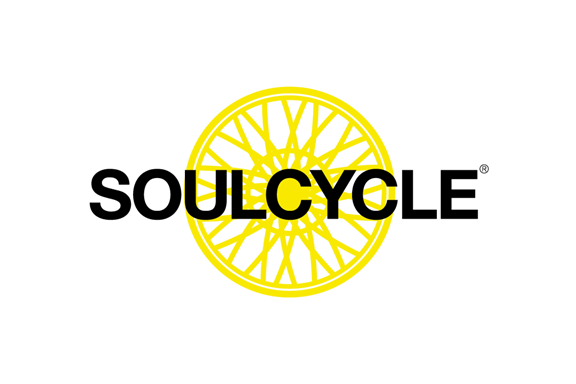 SoulCycle logo with yellow wheel graphic behind black text.