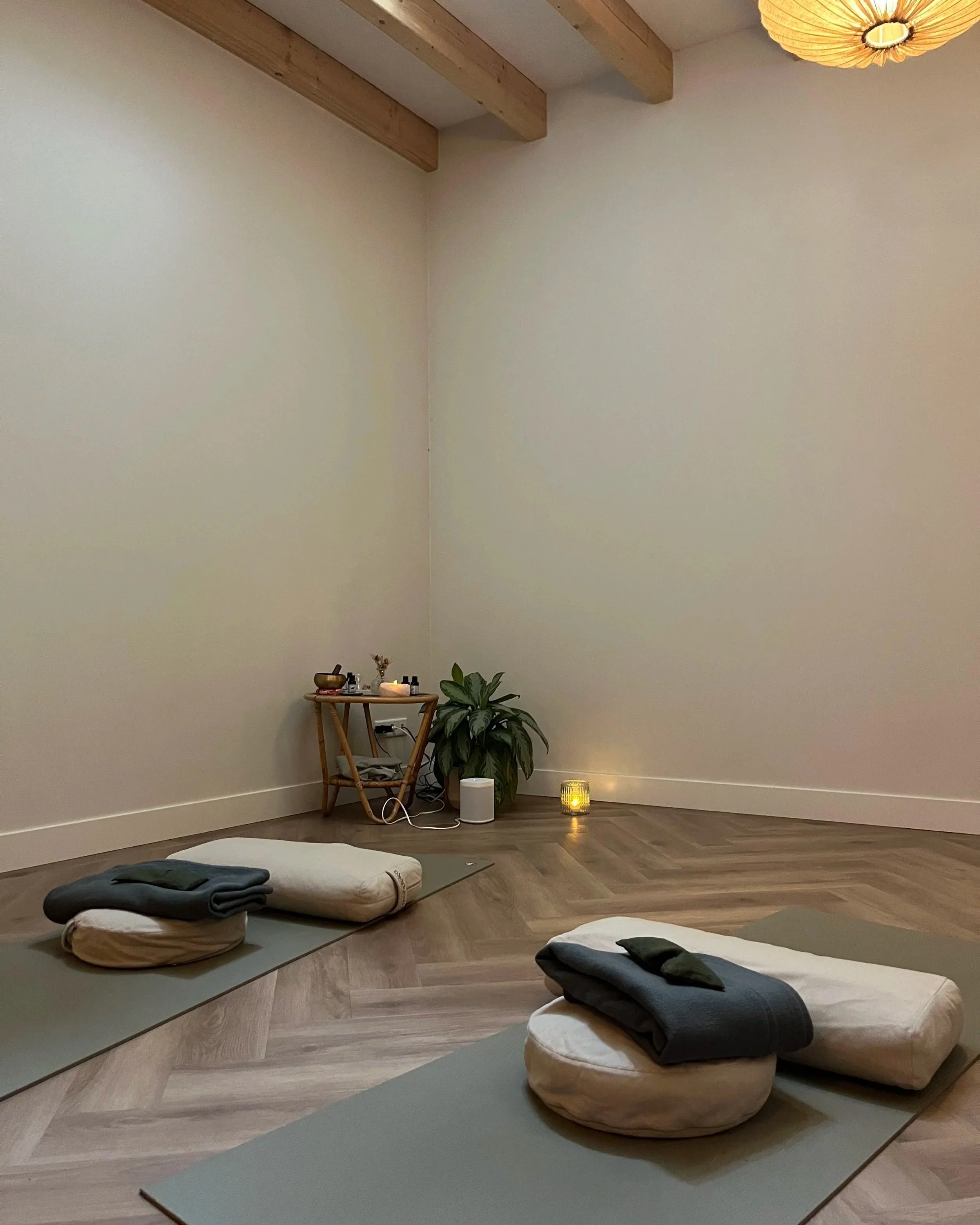 Aesthetic yoga studio with mat, bolsters, candles, blankets and eye pillows