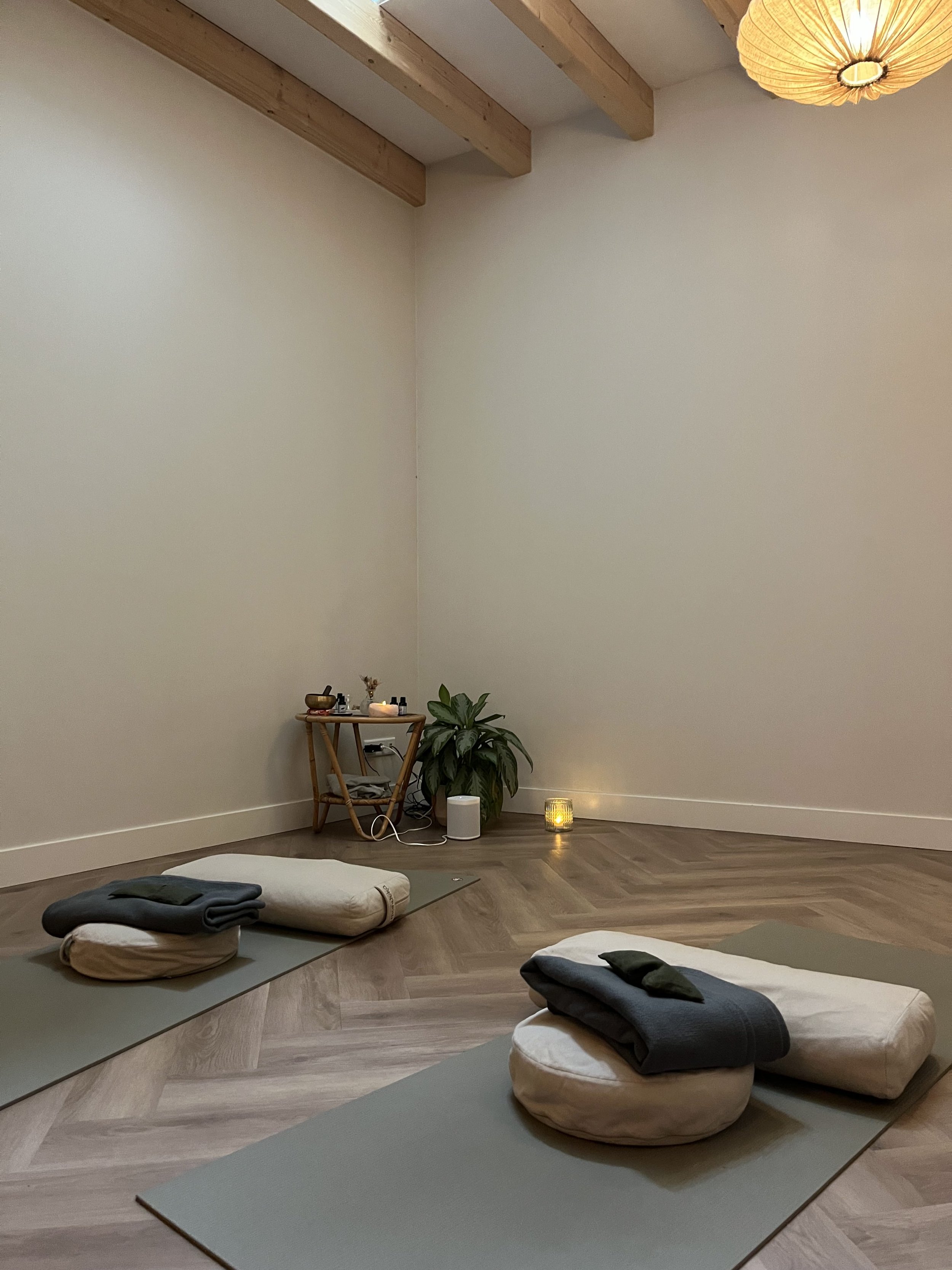 Aesthetic yoga studio with mat, bolsters, candles, blankets and eye pillows