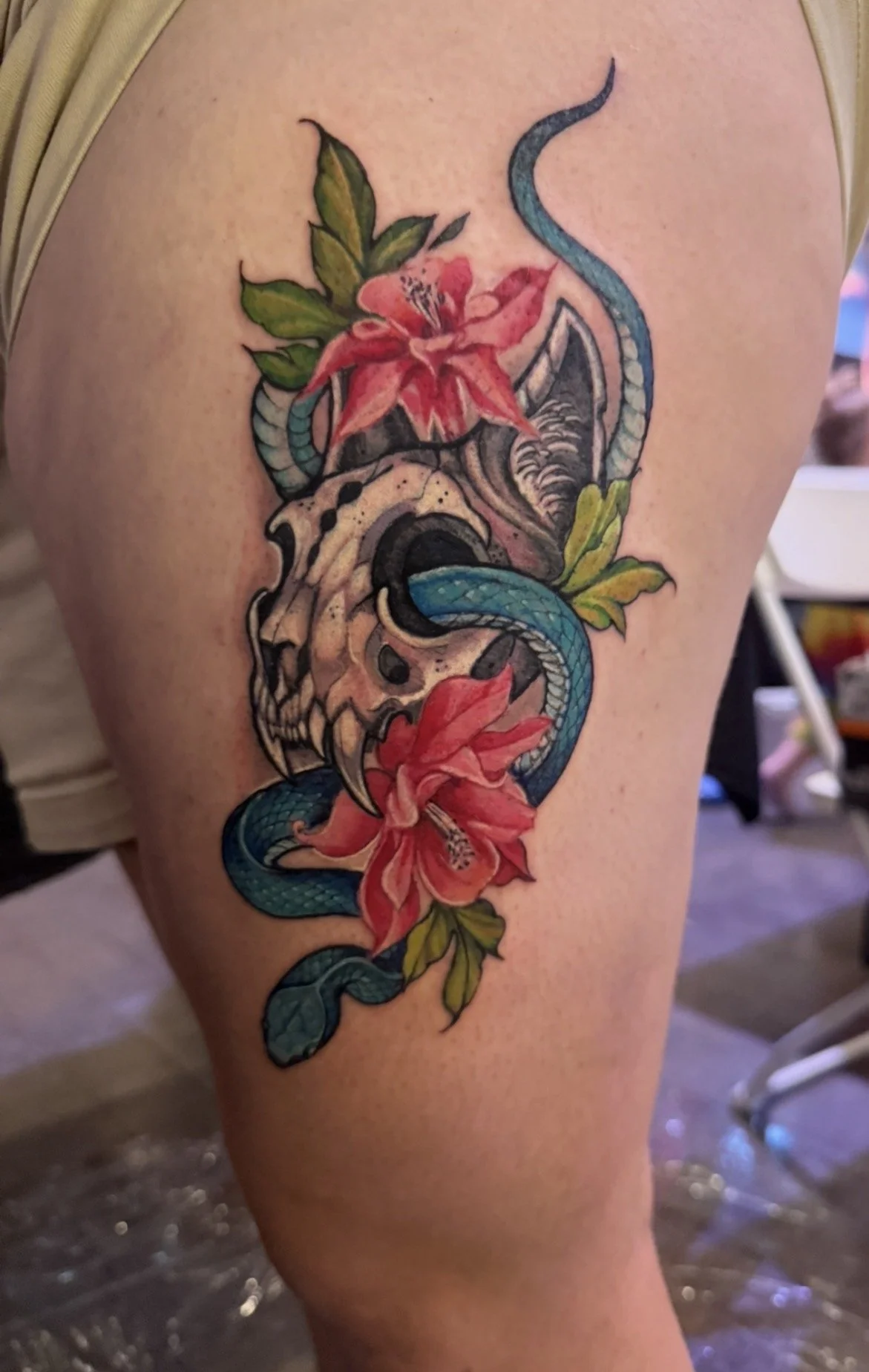 Color tattoo of  skull with blue snake and red flowers