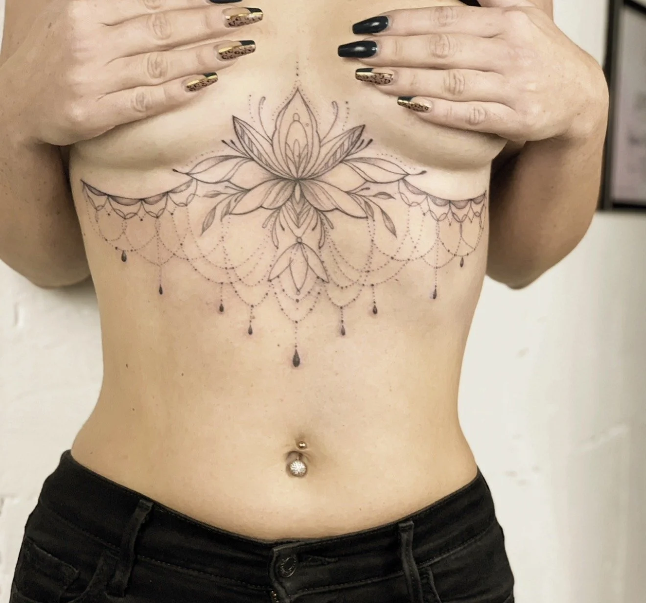 Fine line lotus underboob tattoo with ornamental design