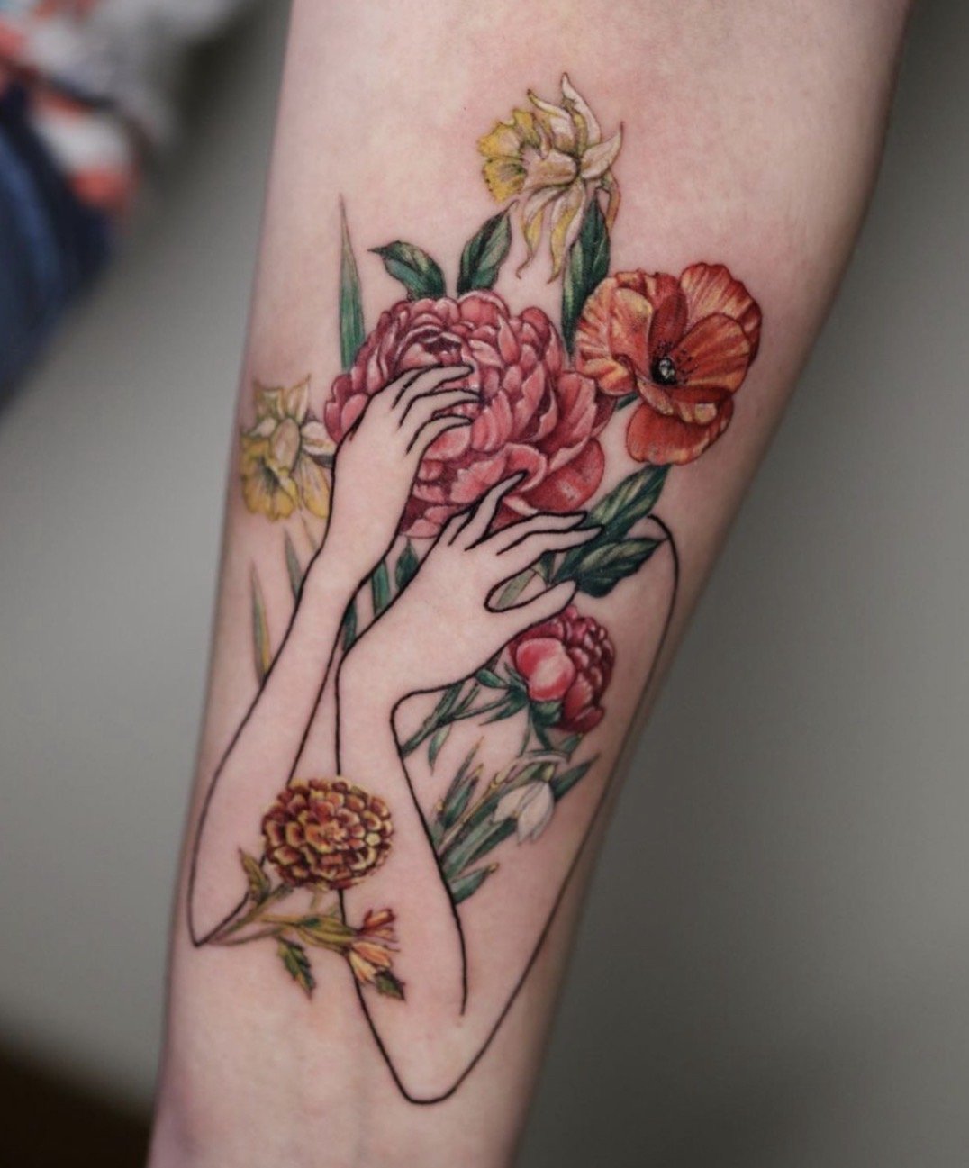 Fine line floral tattoo with hands and flowers