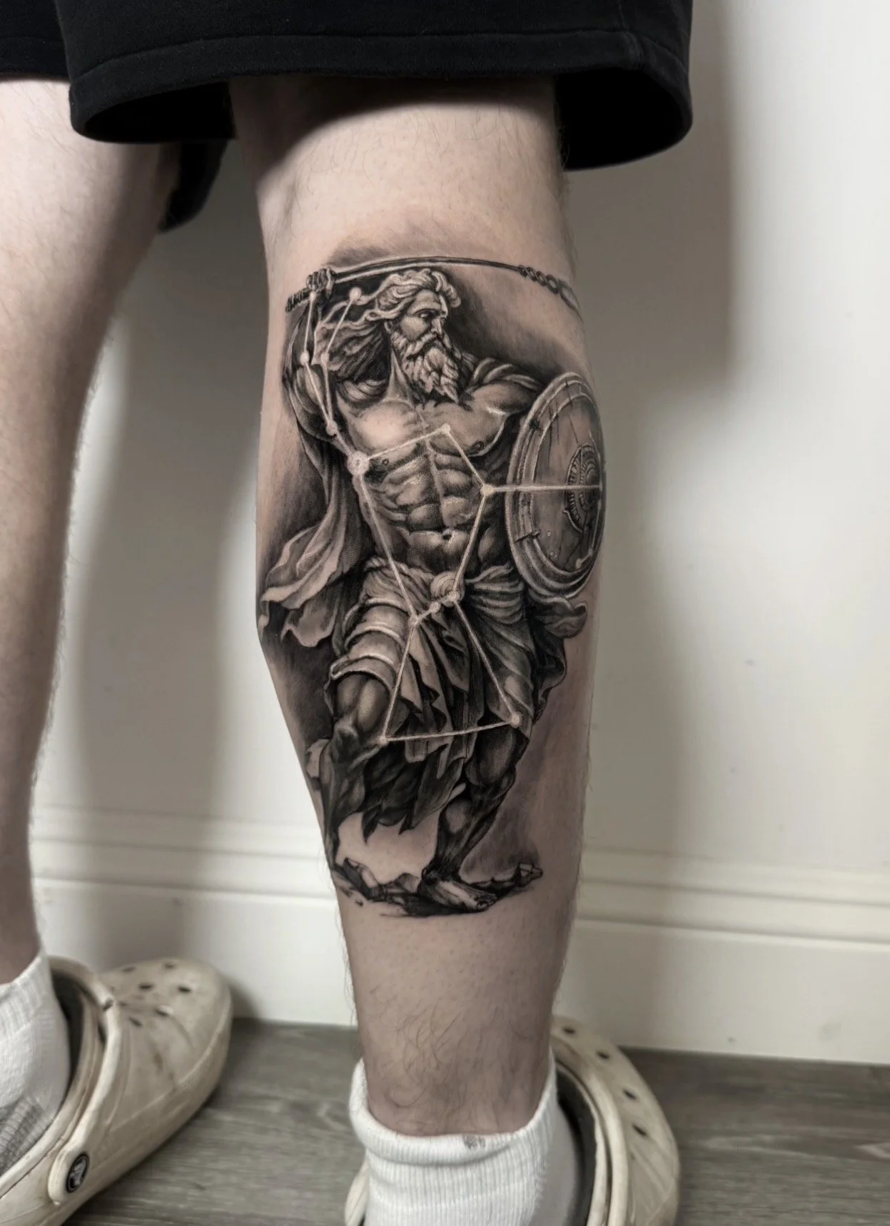 Black and grey Zeus warrior tattoo on calf