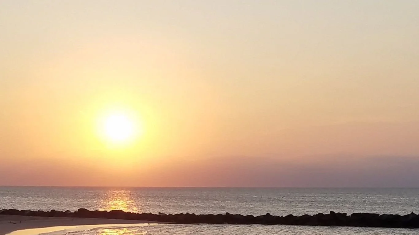 Watch the sunset from the iconic Buckroe Beach lifeguard tower—explore premier oceanfront real estate with Brit Porter, your Hampton Roads luxury home expert.