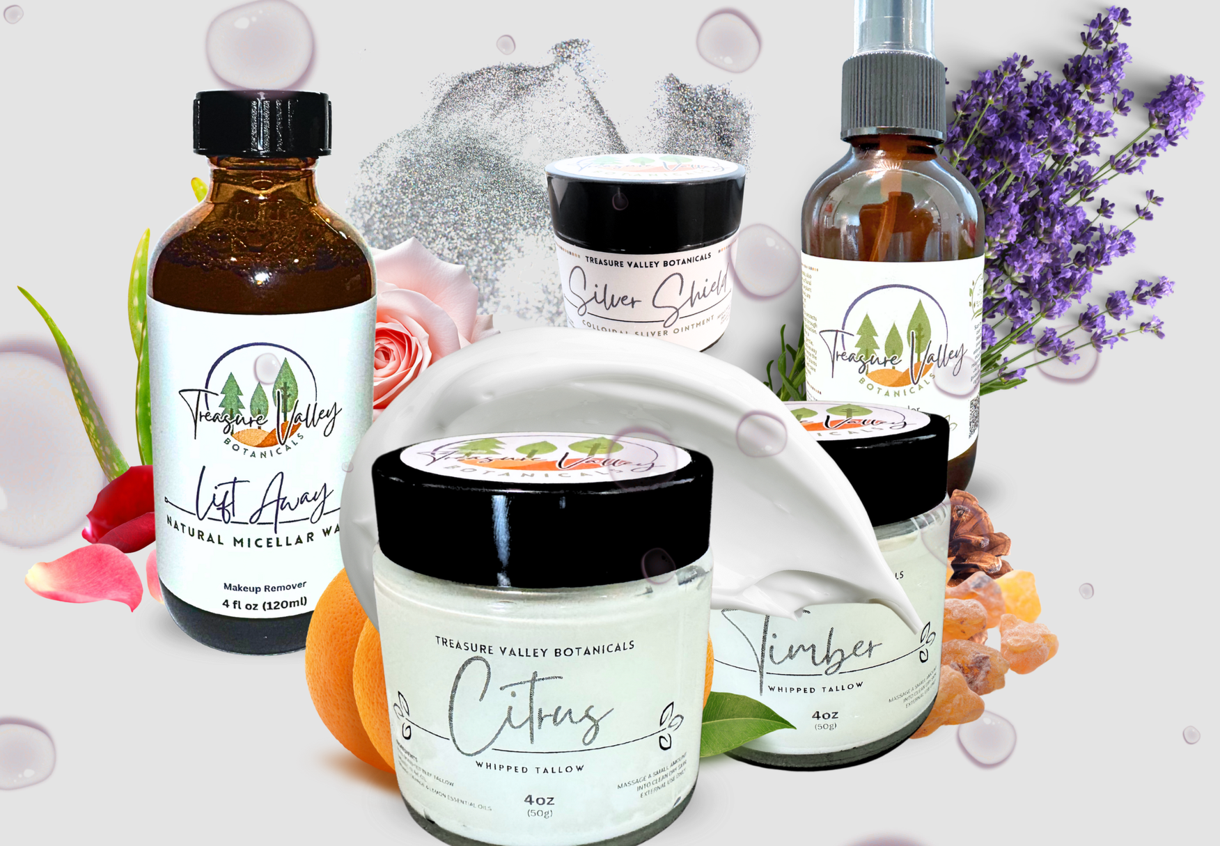 Assorted skincare products from Treasure Valley Botanicals, including a citrus whipped tallow, natural makeup remover, colloidal silver balm and other natural skincare items, surrounded by flowers and botanical ingredients.