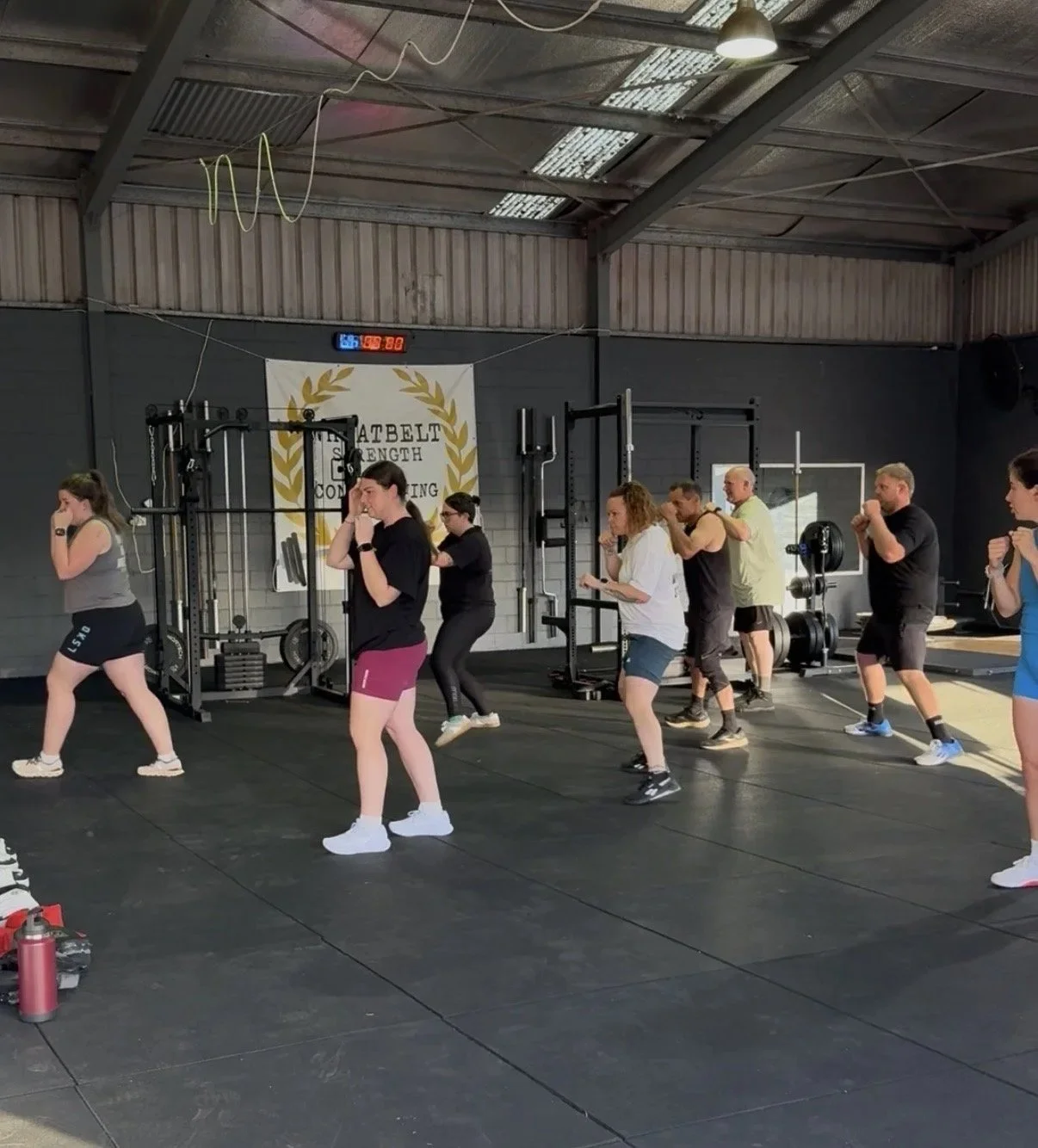 Group of people in fitness attire warming up for boxing class