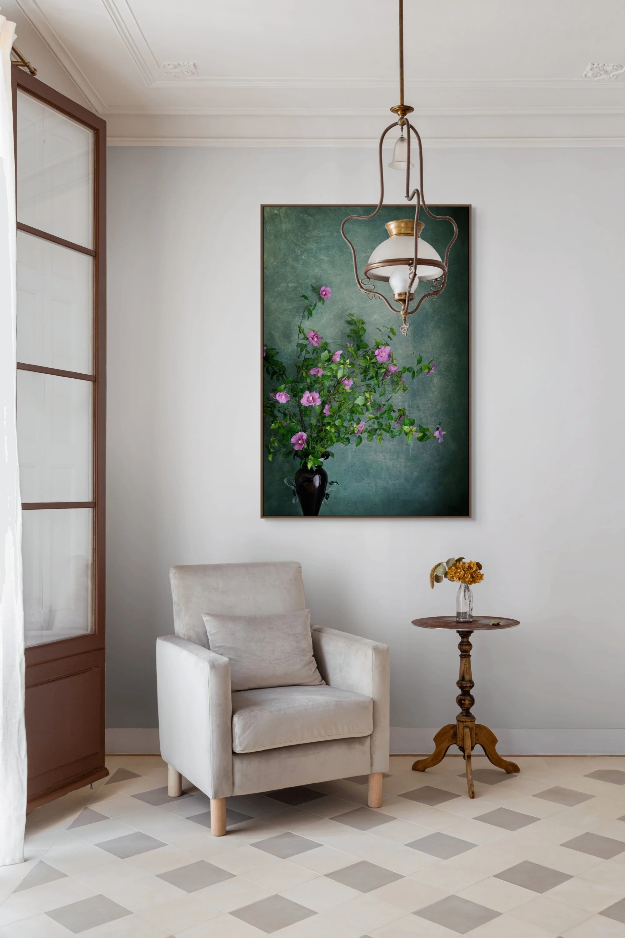Pink hibiscus flowers arranged in a dark glass vase against a textured teal background.