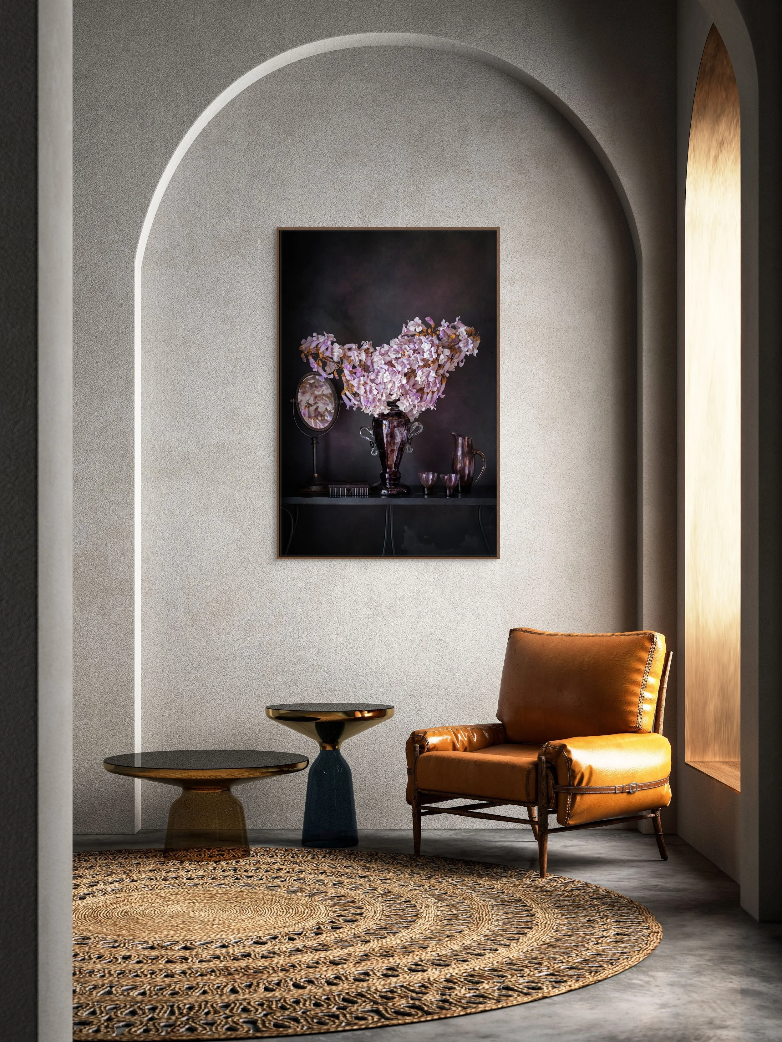 Lilac paulownia blossoms arranged in a dark glass vase with vintage objects.