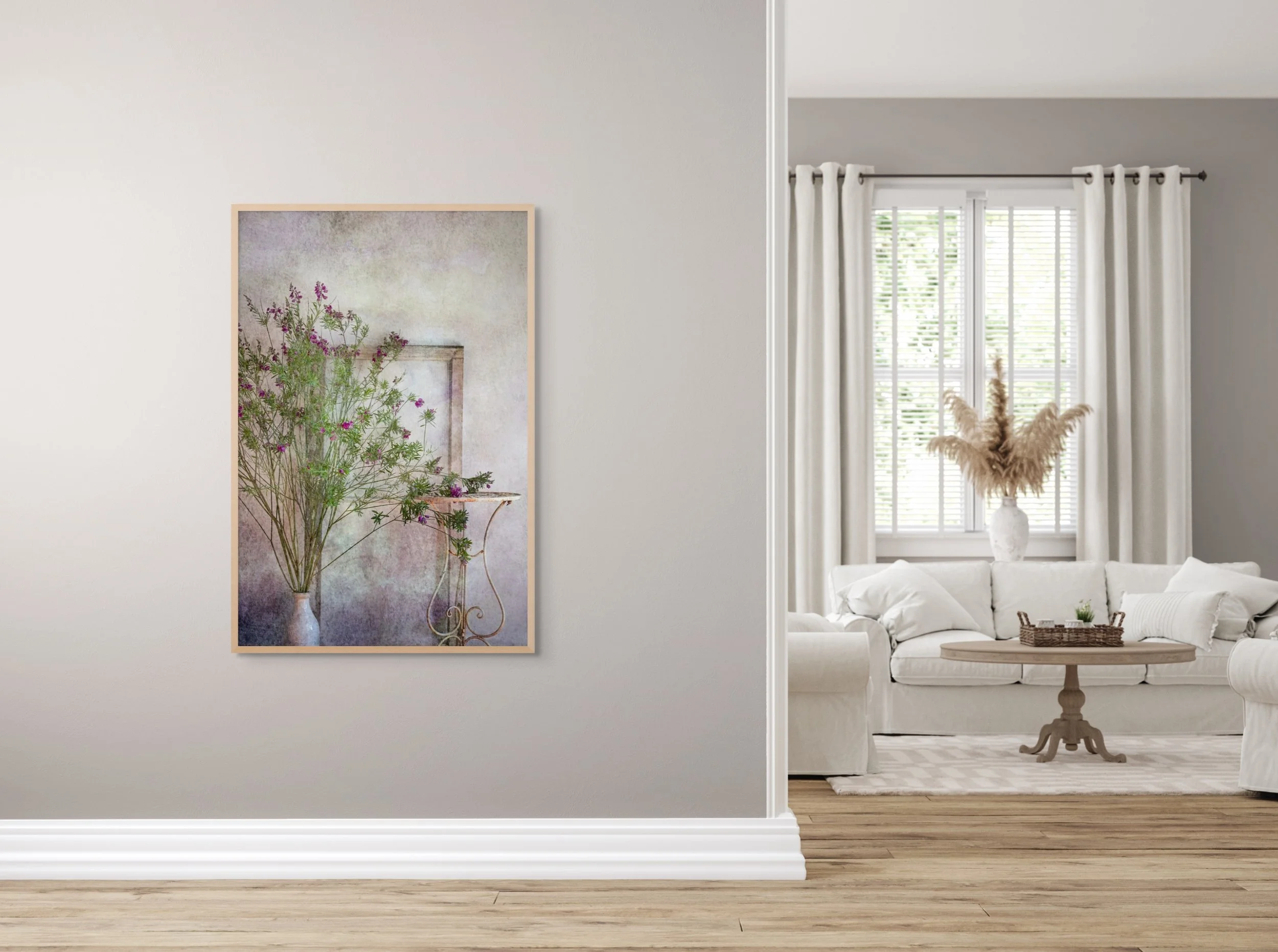 Delicate purple wildflowers in a vase beside a vintage stand and frame.