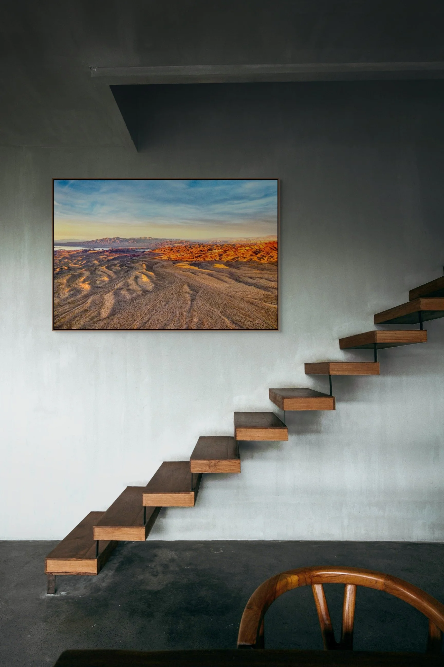Golden sunset light across desert ridges and distant mountains landscape.