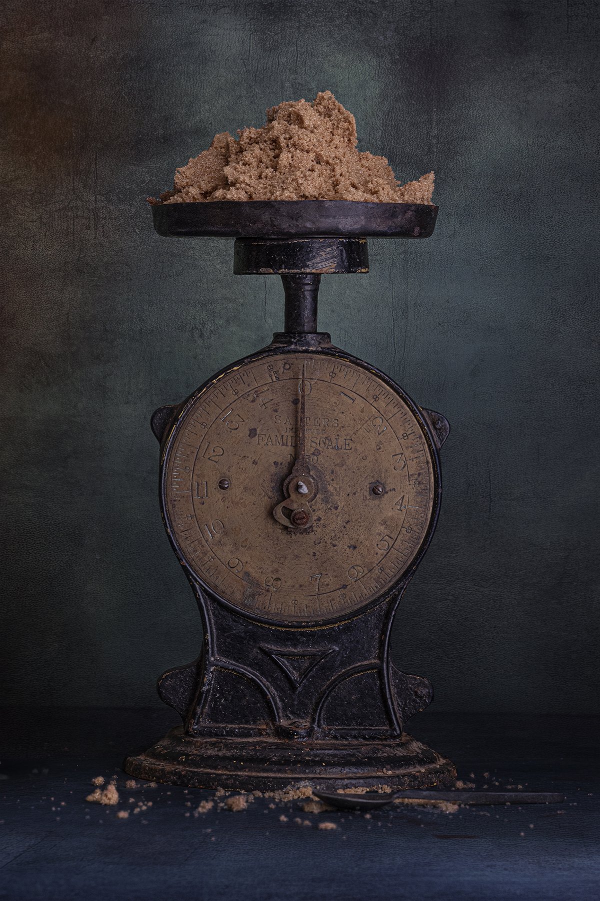 Vintage kitchen scale holding raw sugar in a moody still life photograph.