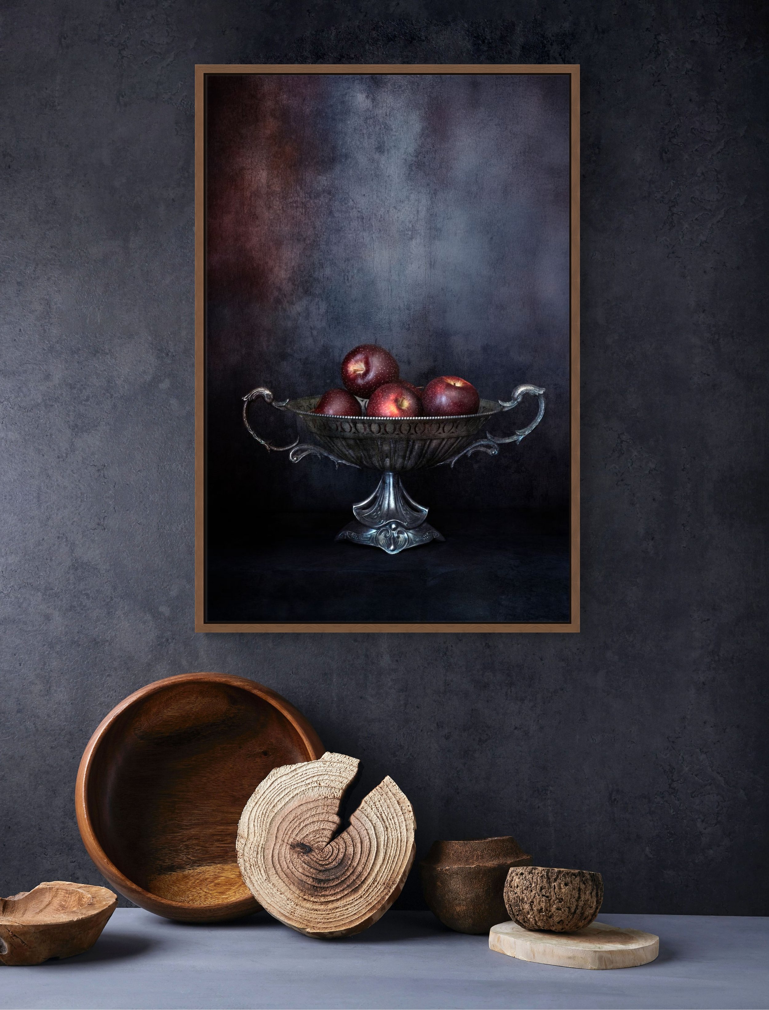 Red apples in vintage silver bowl in moody still life photography.