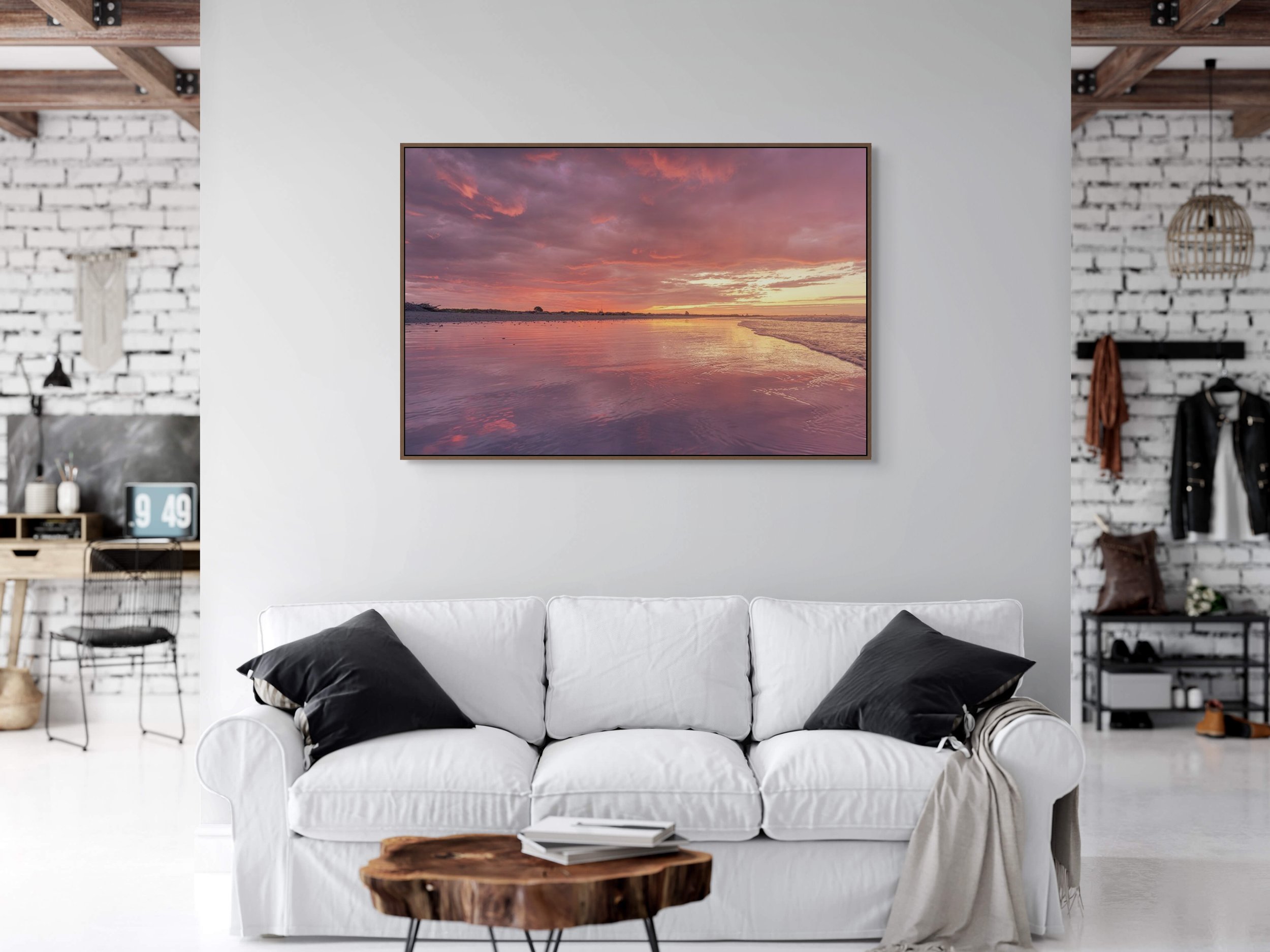 Golden sunset reflecting across calm ocean water and shoreline.