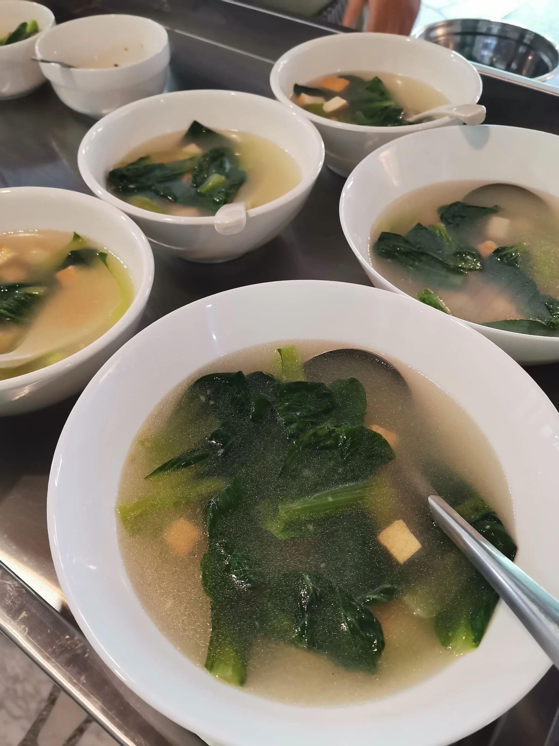 Bowl of clear soup with seaweed and tofu.