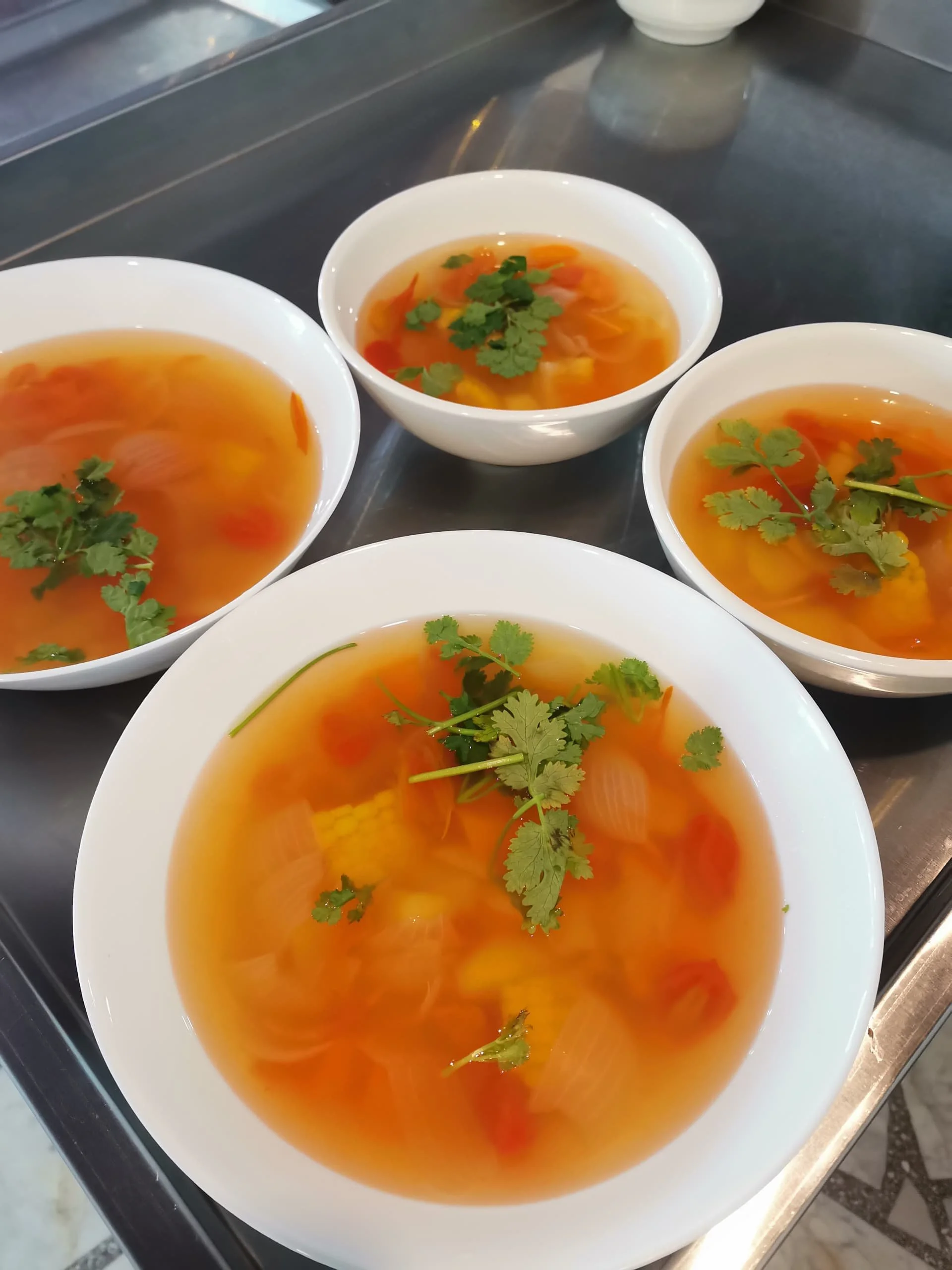 Bowl of hot and sour soup garnished with fresh cilantro.