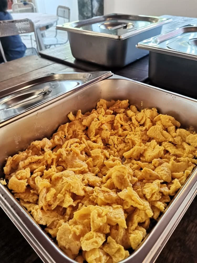 A tray of scrambled eggs on a serving table.