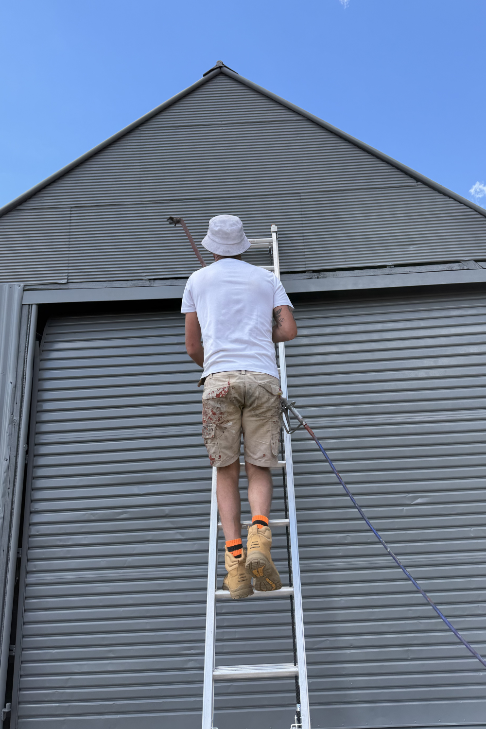 Alfie Hendry of Hendry’s Restorations painting a shed grey.