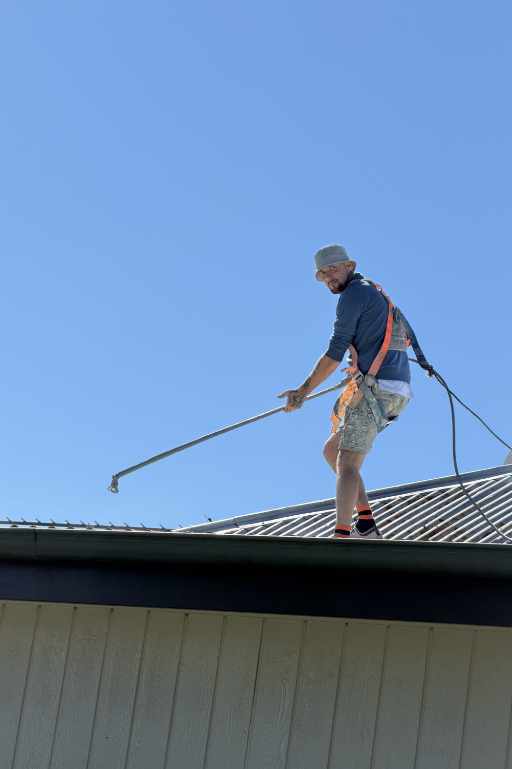Alfie Hendry of Hendry’s Restorations spray painting a roof in Capella, Queensland.
