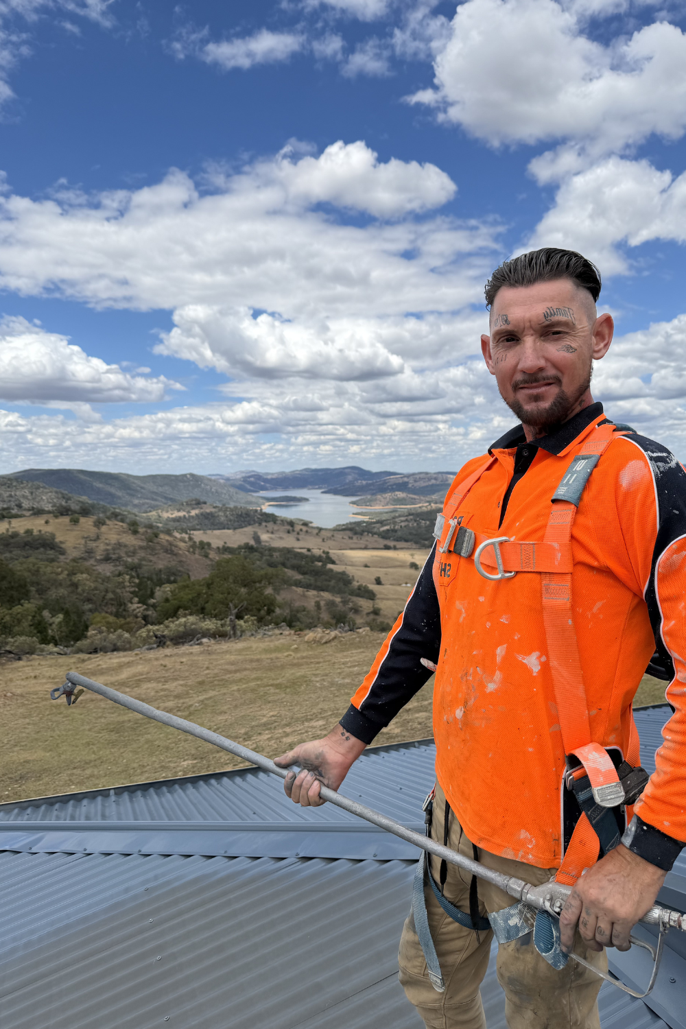 A roof painter in Duaringa with a spray painting gun on a roof.