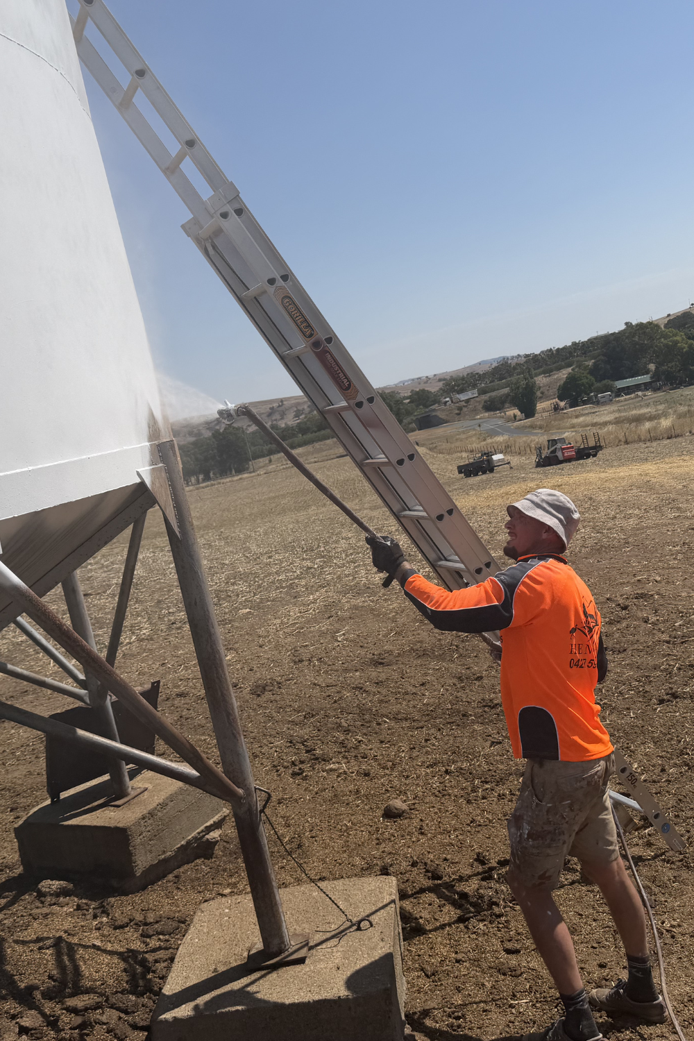 Alfie Hendry painting a silo on a farm on Injune Queensland.