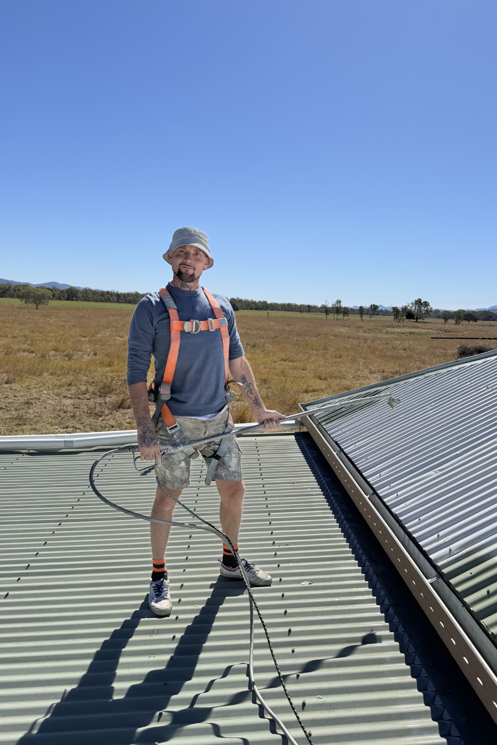 Alfie Hendry of Hendry’s Restorations spray painting a roof in Springsure, Queensland.
