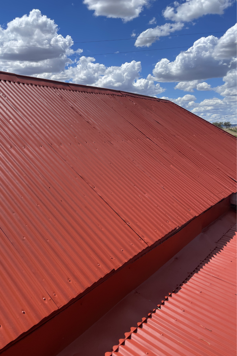 A roof after painting with a heat-reflective, rustproof red coating.