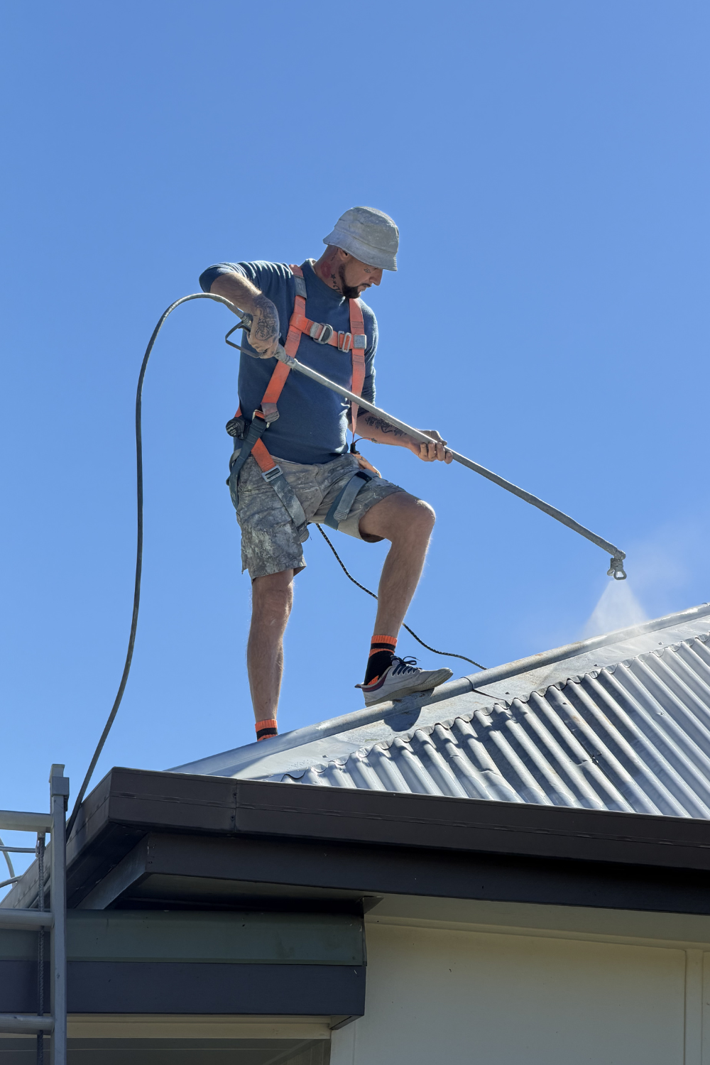 A spray painter near Mitchell, Queensland spray painting a rusty roof.
