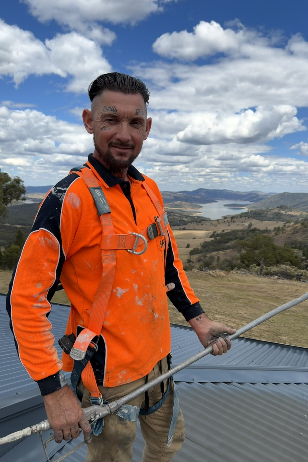Alfie Hendry of Hendry’s Restorations on a roof in Bluff with a spray gun on a roof.