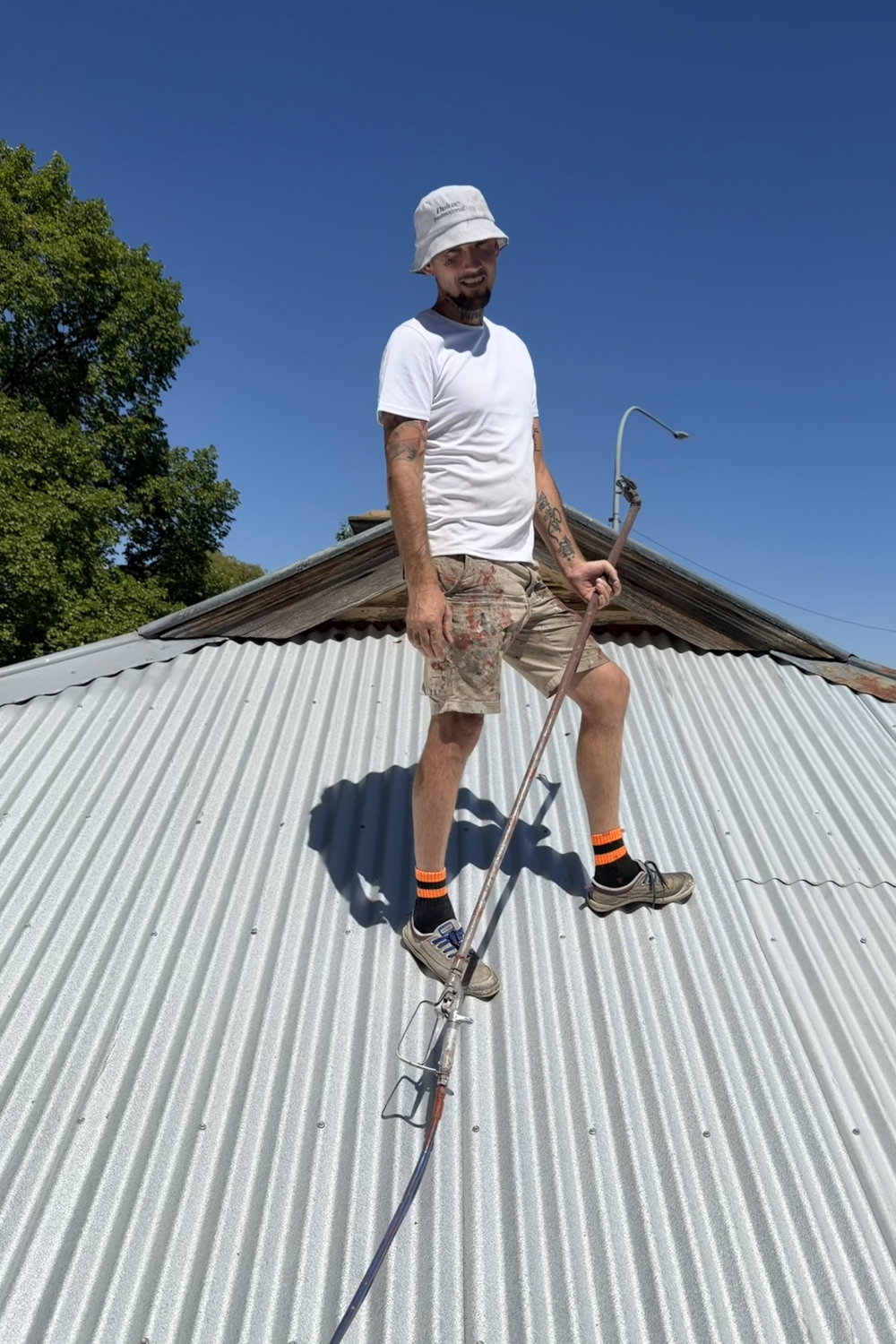 Alfie Hendry of Hendry’s Restorations - a roof painter painting a roof in Surat.