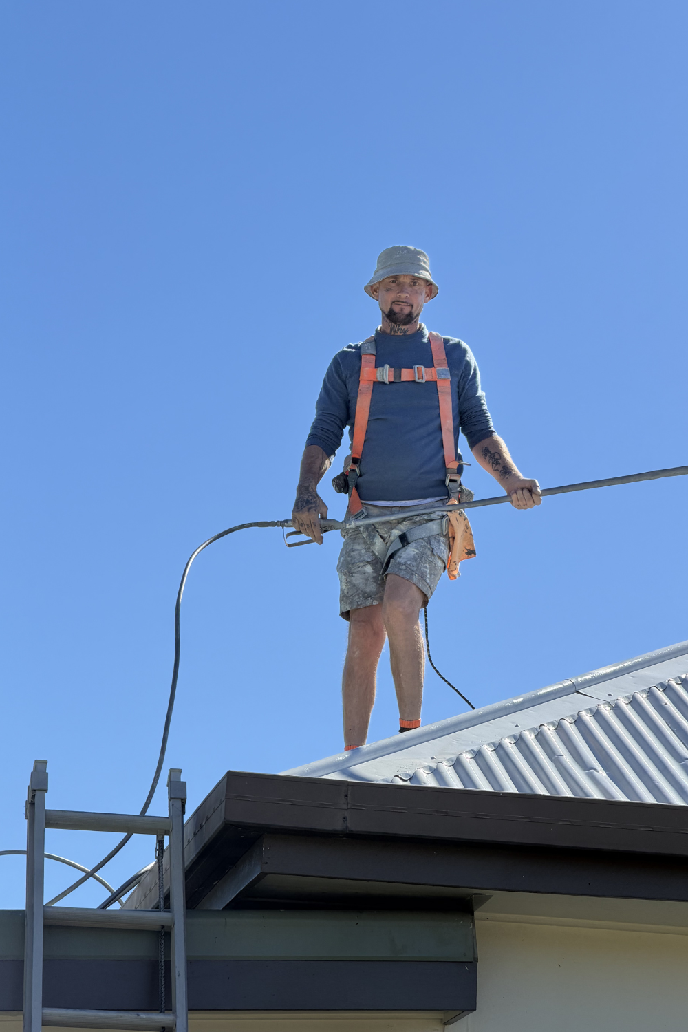 Alfie Hendry of Hendry’s Restorations spray painting a roof in Roma.
