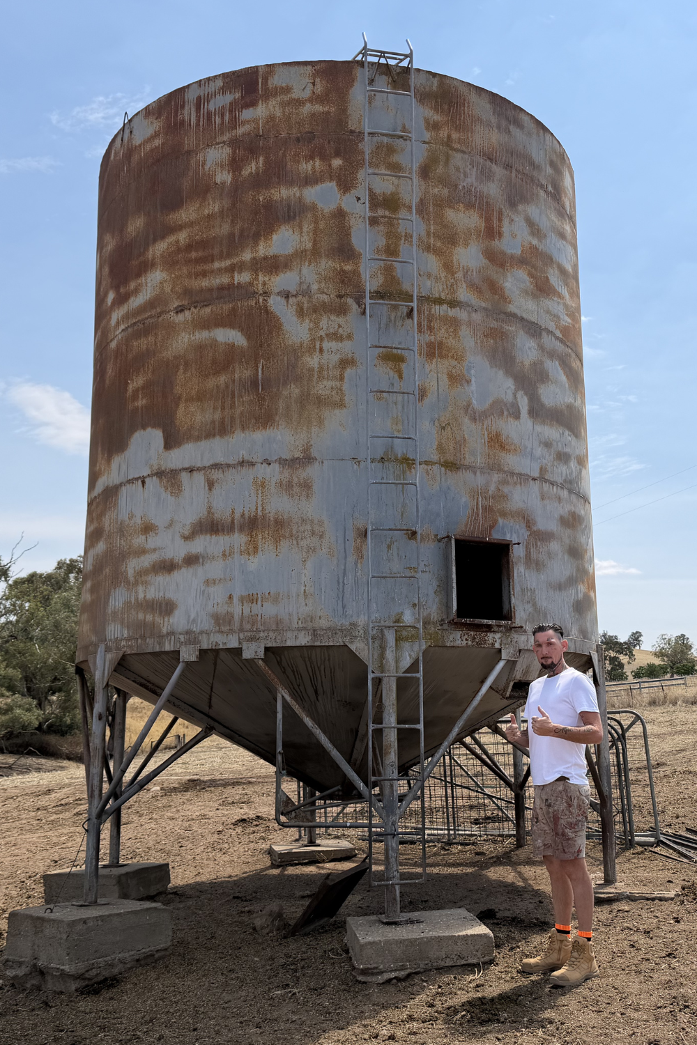 Alfie Hendry of Hendry’s Restorations standing next to a wheat silo in Wallumbilla.