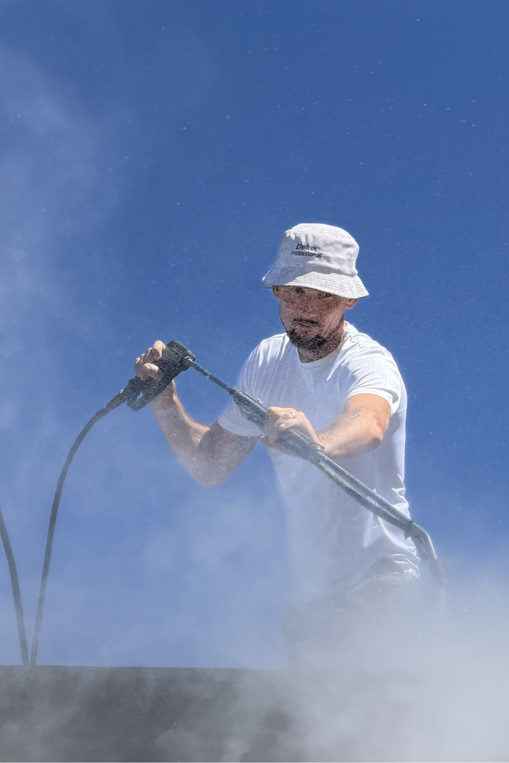 Alfie Hendry power-washing a roof in Queensland.