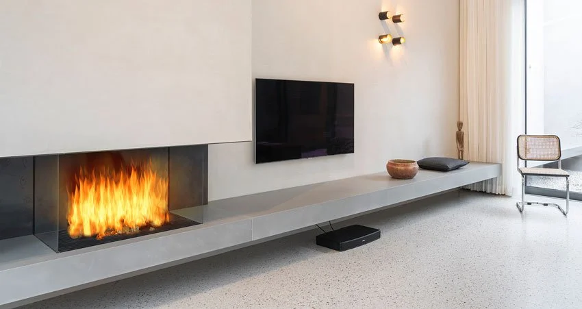 Moderner Wohnzimmerbereich mit Kamin, Fernseher, Dekorationsgegenständen und einer durchgehenden Sitzbank aus Beton.