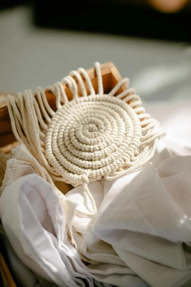 Close-up of a coiled rope mat on fabric, in a wooden box.