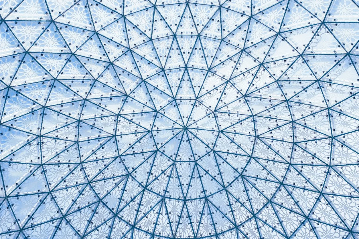 Geometric glass ceiling with intricate pattern and blue hues