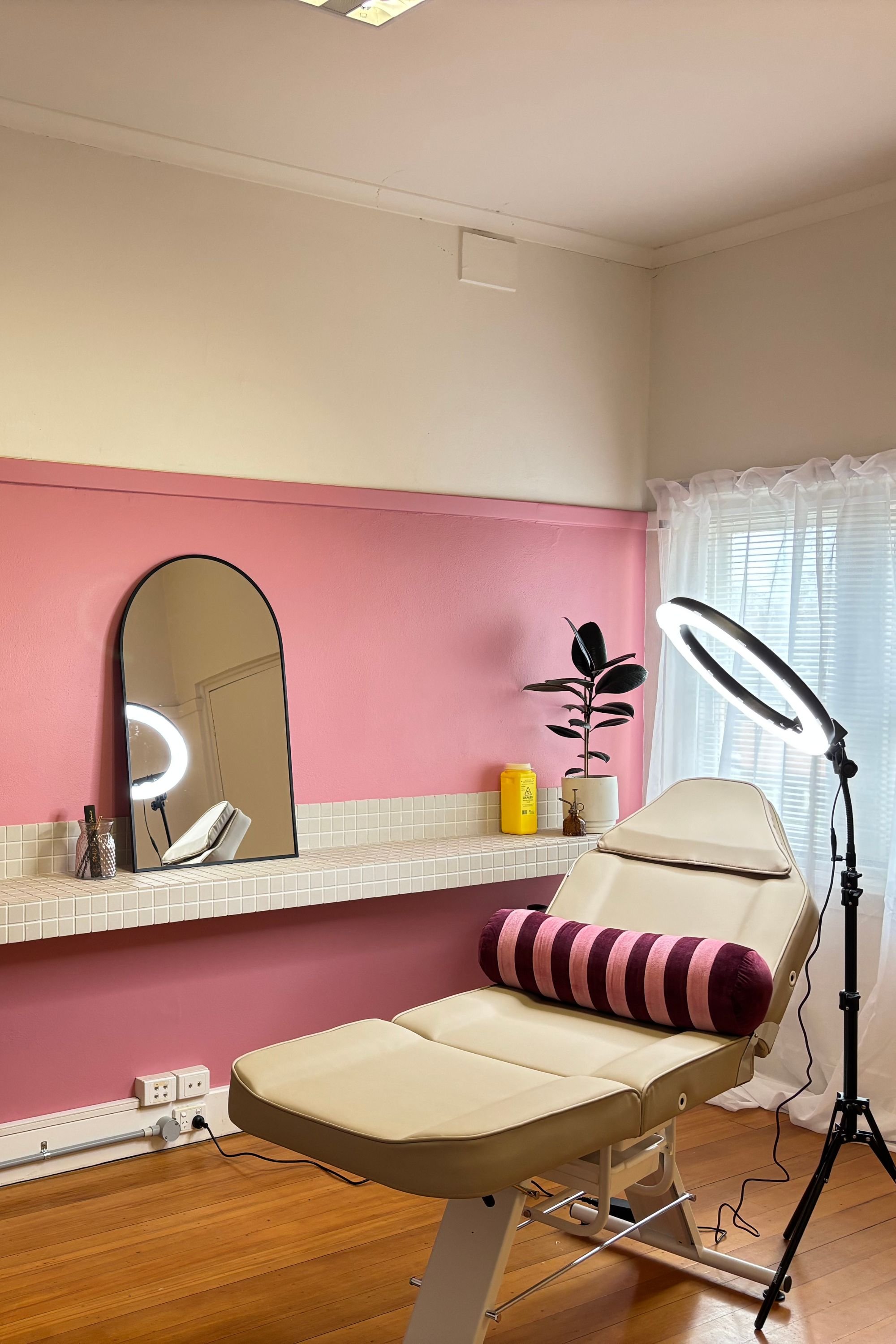 Clean studio image showing a cosmetic tattoo table, bolster and ring light for semi permanent make up procedures