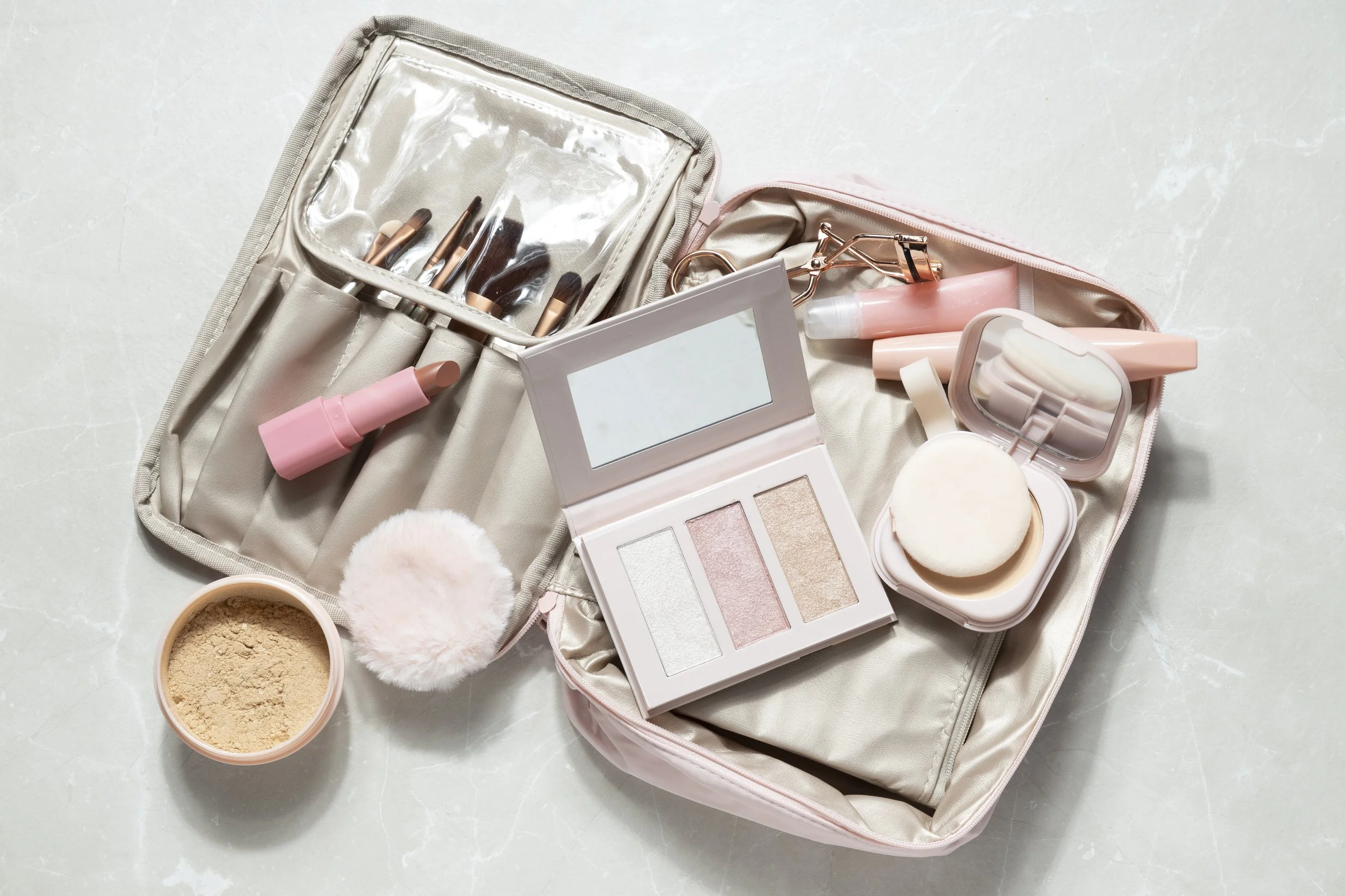 Trousse de maquillage contenant pinceaux, poudrier, palettes de maquillage, beauté éponges, et autres produits cosmétiques