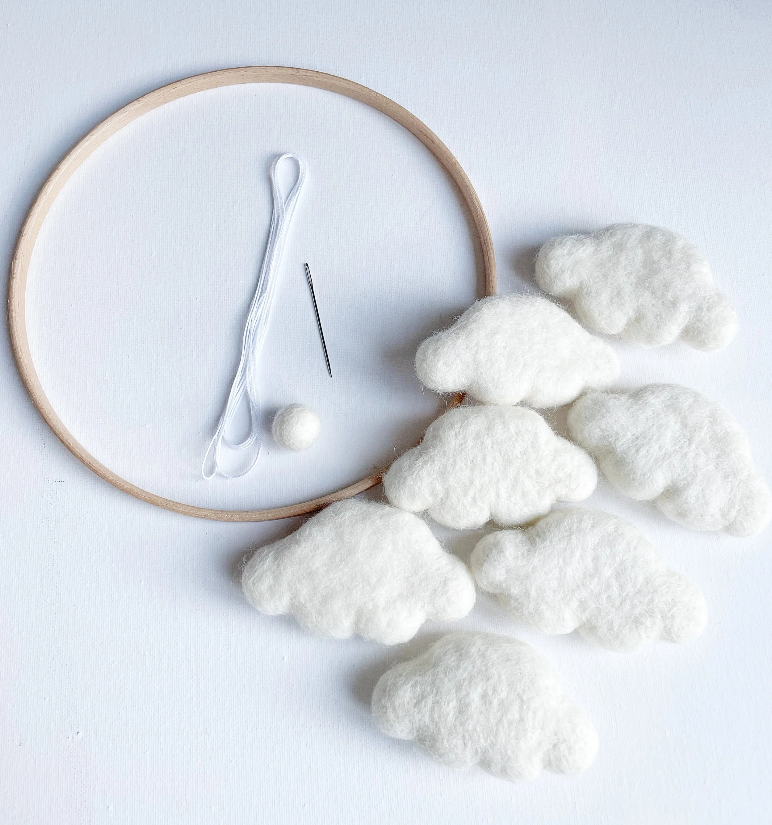 Wooden hoop, needle, string, ivory felt ball and seven ivory wool felt clouds