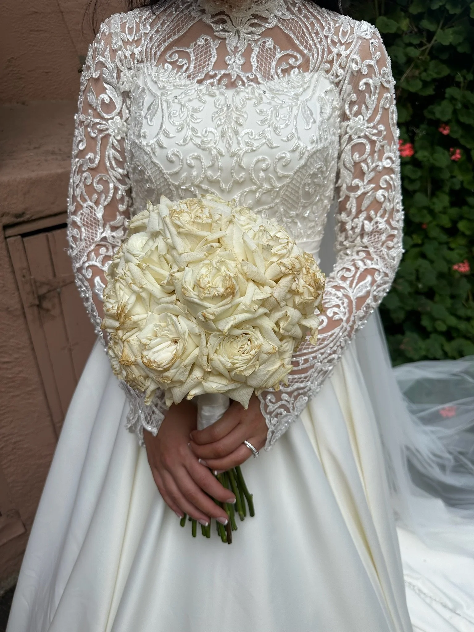 Bride in lace wedding dress holding bouquet of white roses. Captured by Melbourne Wedding Content Creator Dania.