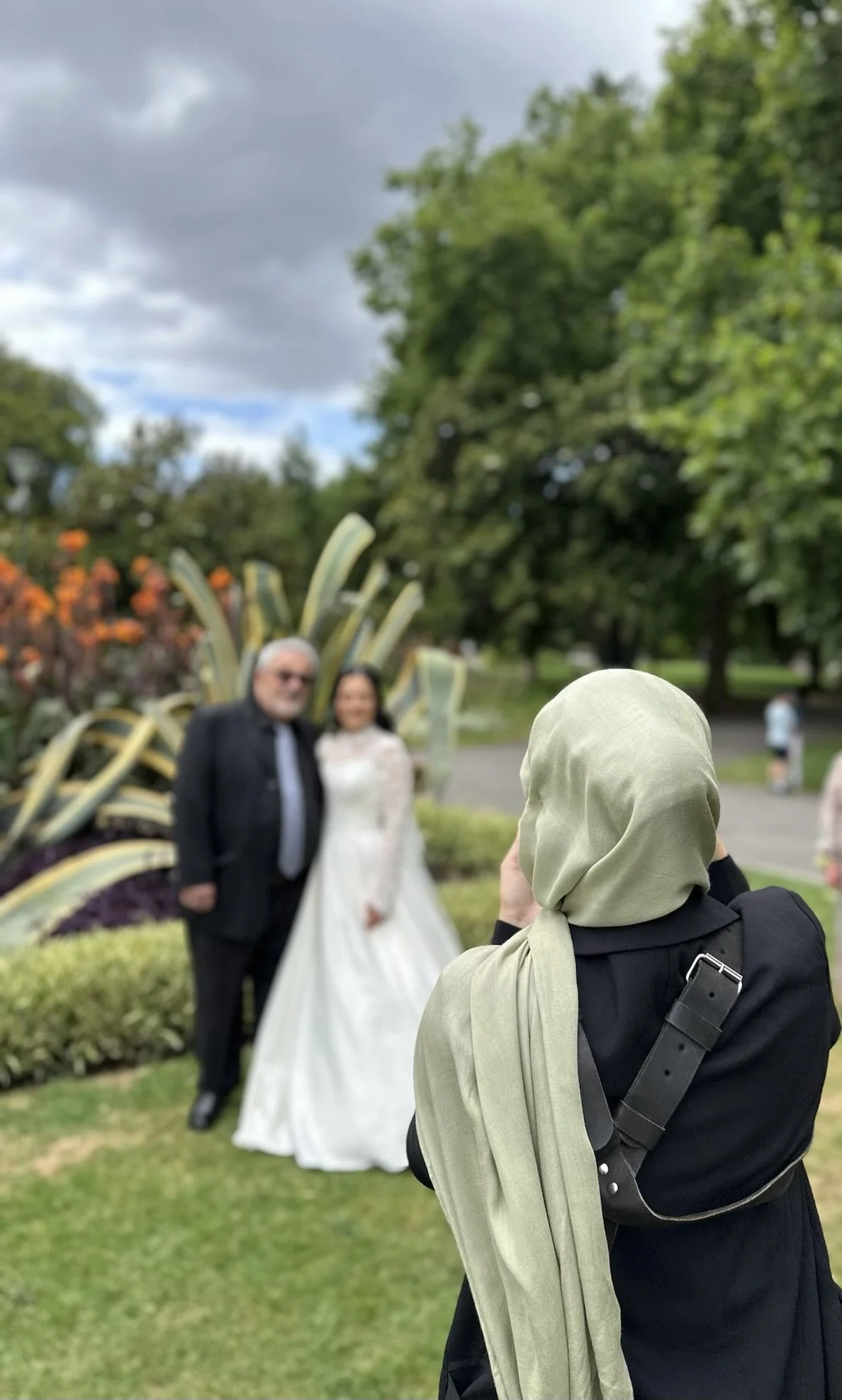 Photographer taking picture of couple in a garden