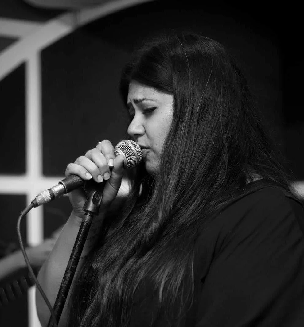 Prachi Kapil singing with a mic in hand
