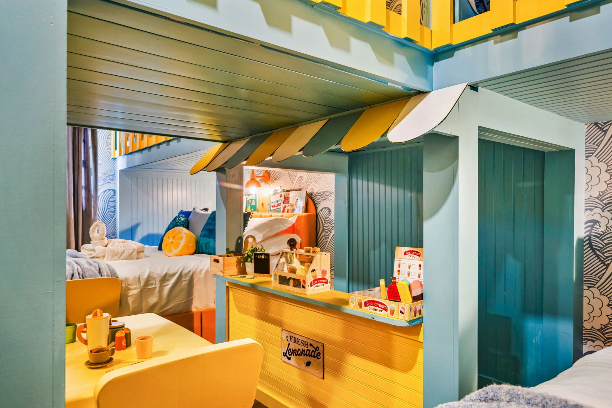 Colorful children's playhouse with a lemonade stand, beds, and playful decor