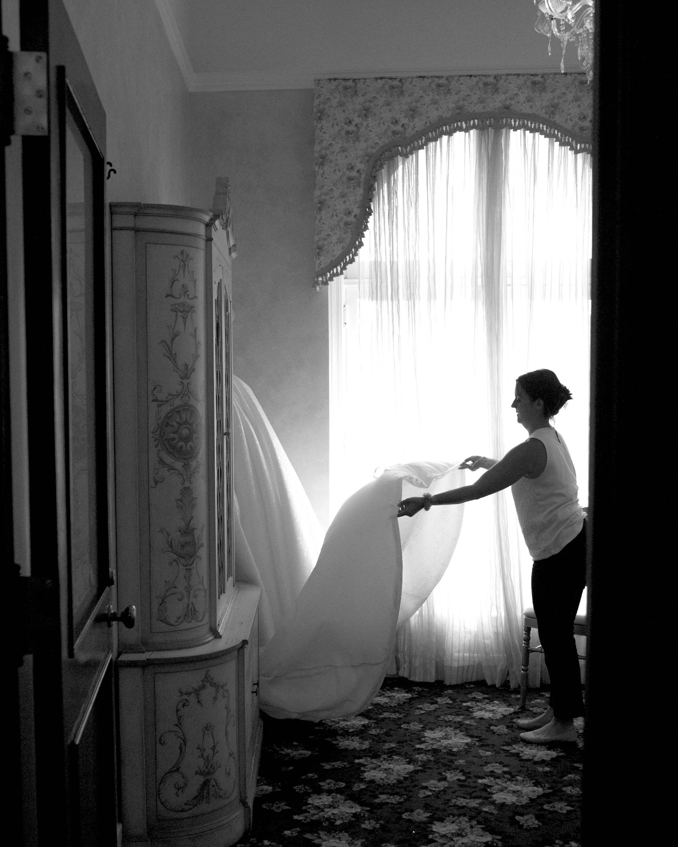 Person setting up or adjusting a curtain in a room with vintage decor