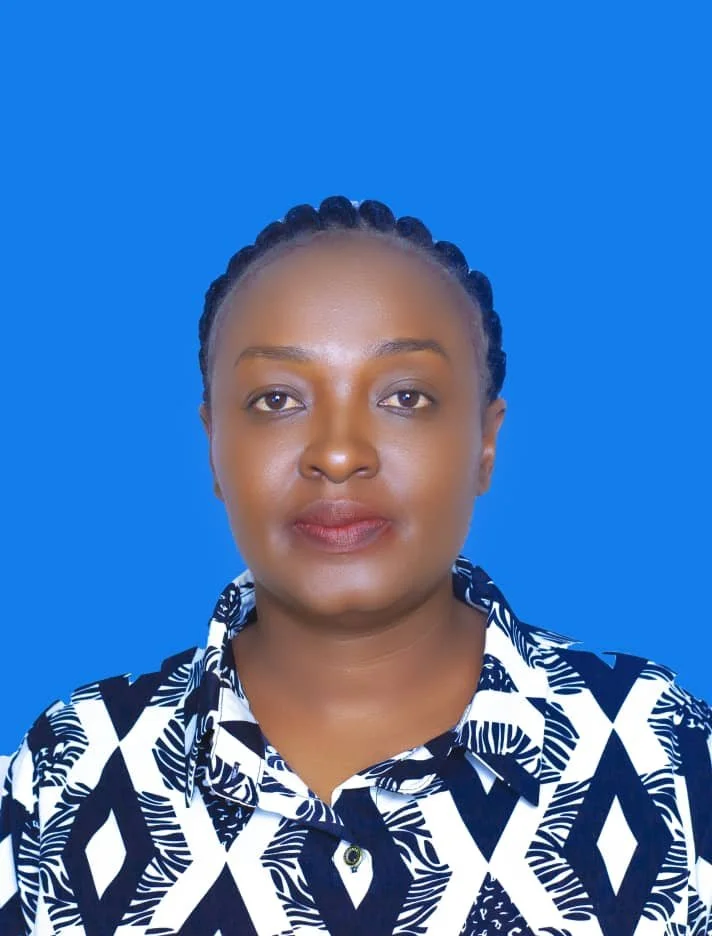 A woman wearing a black and white patterned shirt against a blue background.