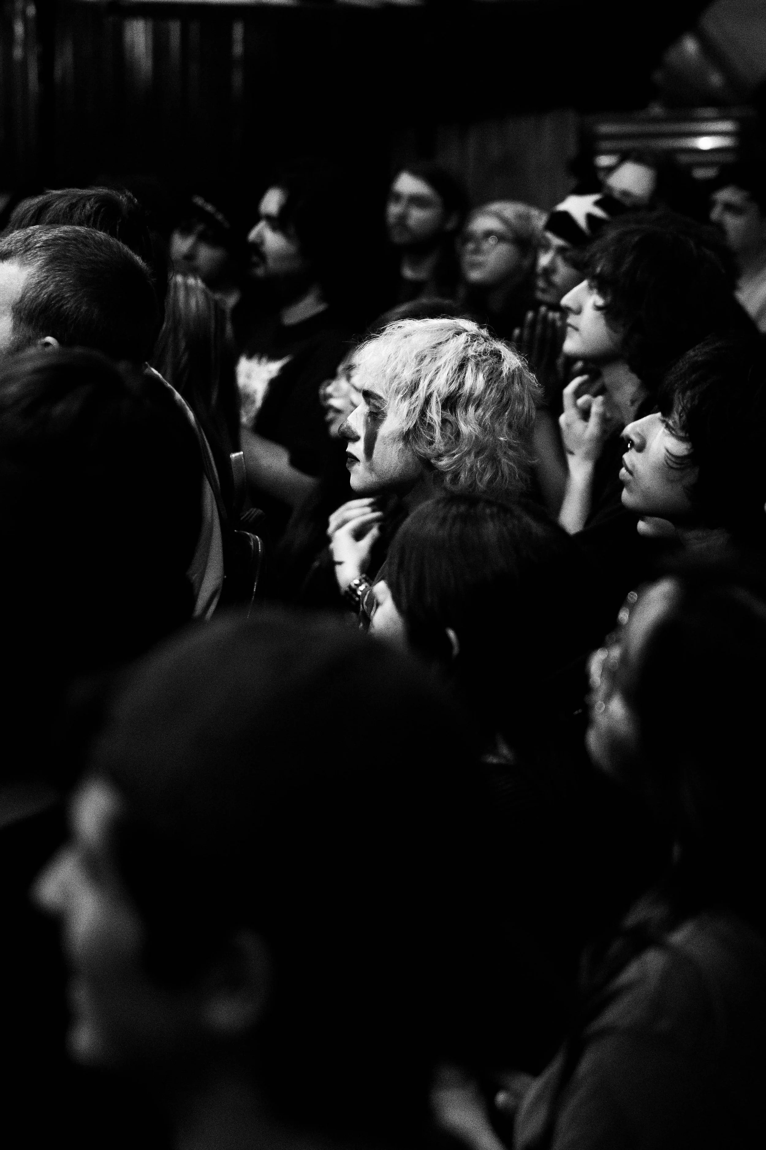 A concert attendee in clown make up watches a show at Rubber Gloves Rehearsal Studio on Oct. 22, 2024