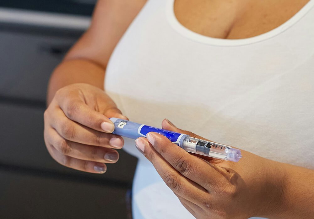 Woman holding a GLP-1 injector pen
