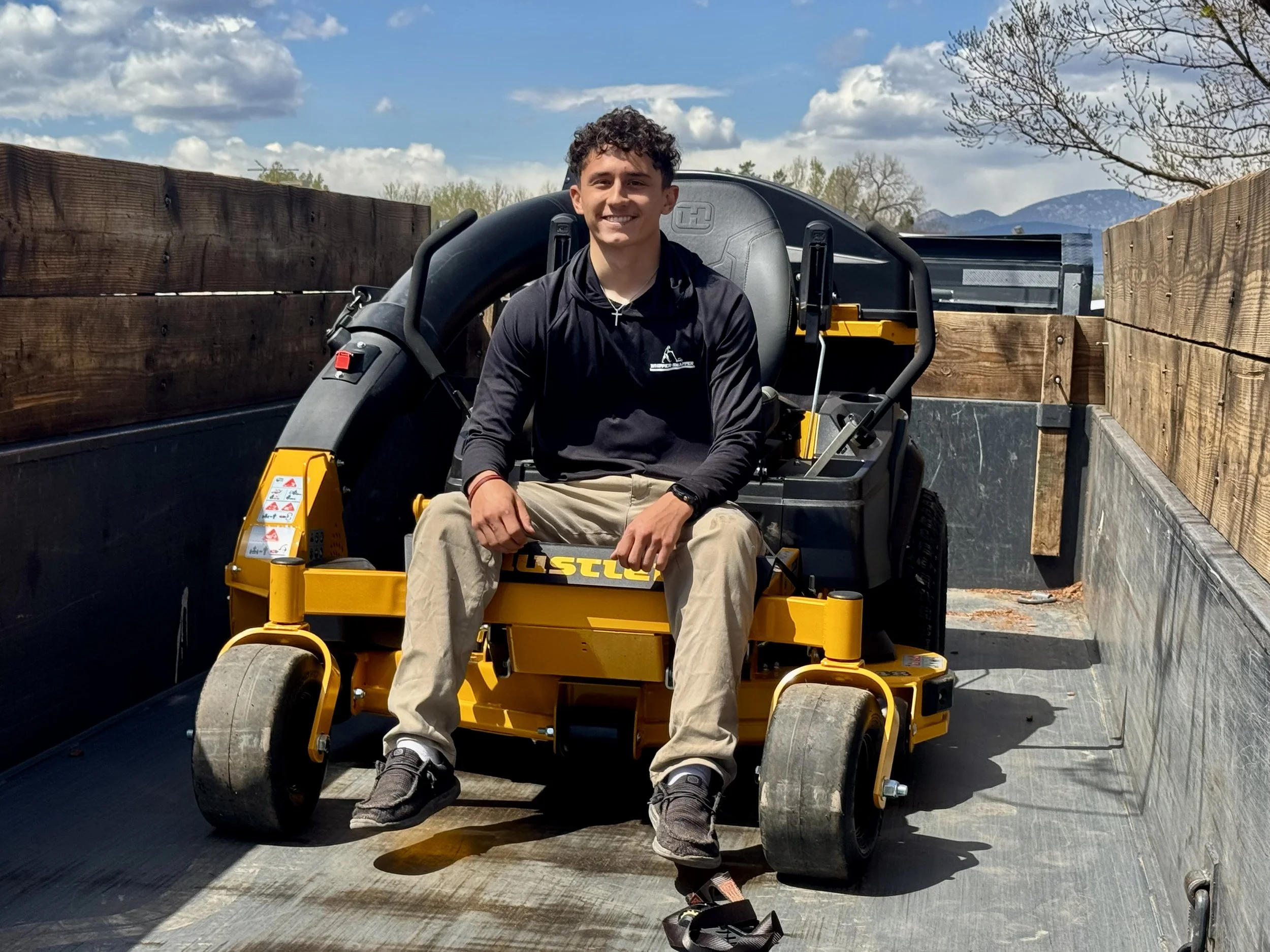 Owner of Whipper Snapper Lawn Care posing on a lawn mower in Johnstown, Colorado